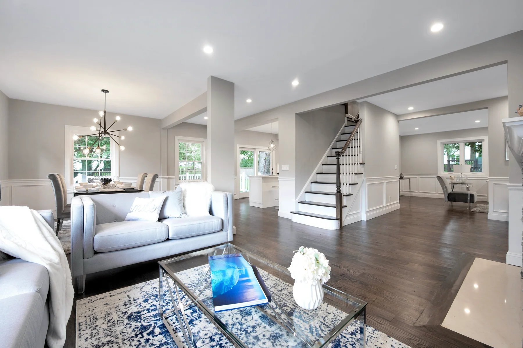 Dark stained oak in a staged living room beside an open staircase