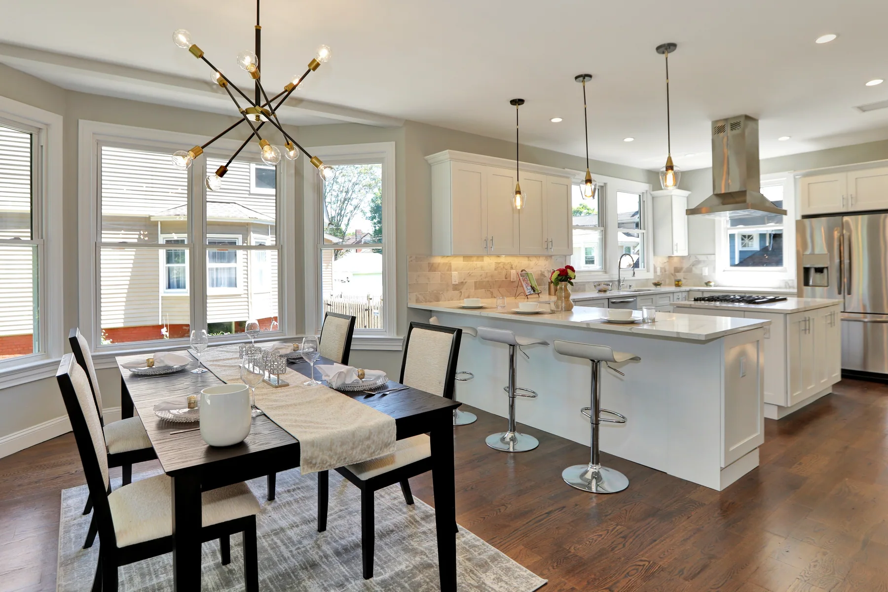 Warm hardwood flowing continuously through an open dining and kitchen space