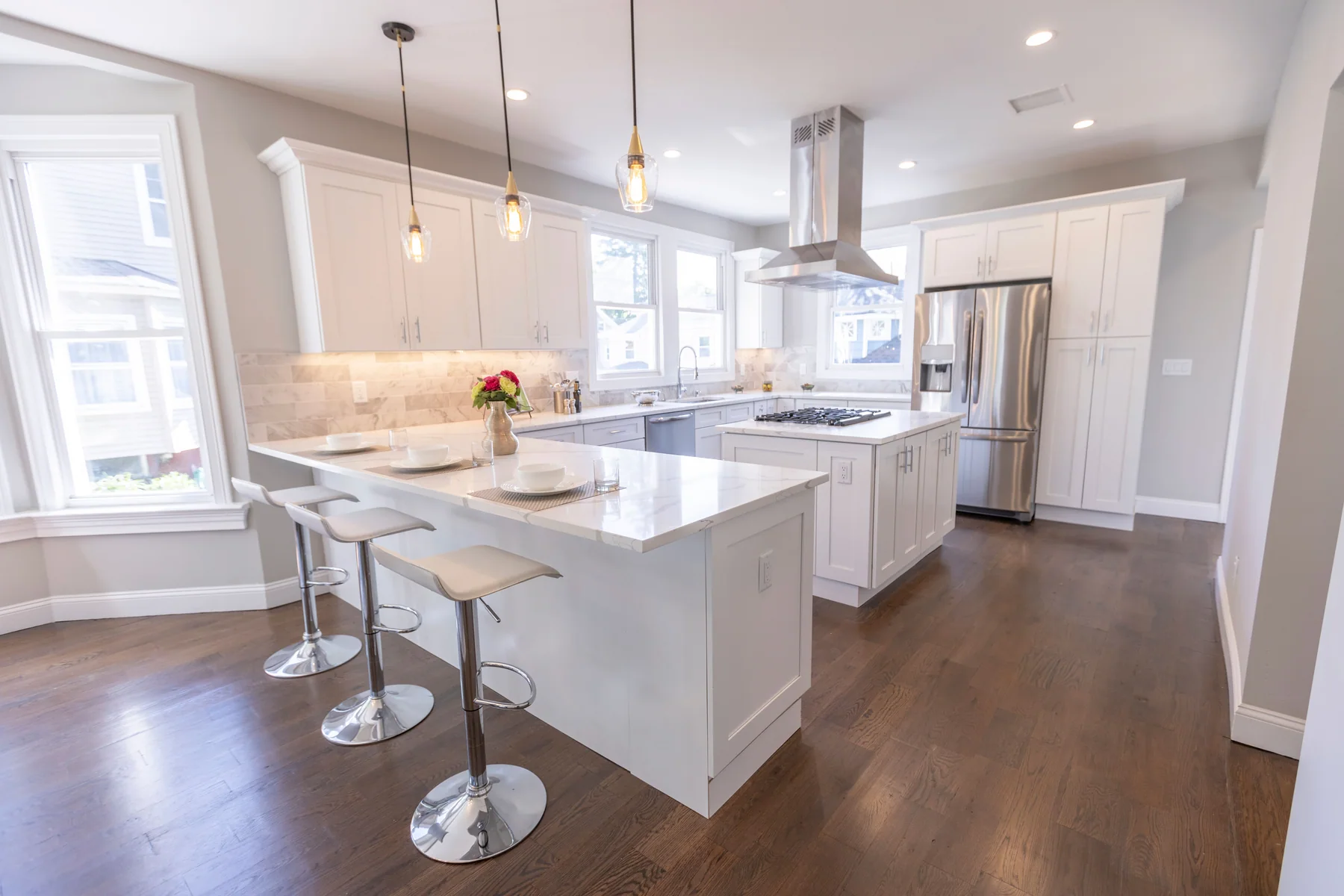 Dark oak set against a bright white kitchen and island